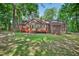 Exterior of a cozy home with a wooden deck, lush backyard, and surrounded by mature trees at 4816 Marlborough Way, Durham, NC 27713