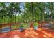 Outdoor deck with cozy seating offers a peaceful view of the fenced backyard and surrounding trees at 4816 Marlborough Way, Durham, NC 27713