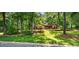Quaint home with a well-maintained front yard surrounded by mature trees, offering shade and privacy at 4816 Marlborough Way, Durham, NC 27713