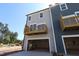 New construction rear elevation featuring an open two-car garage and a balcony with natural views at 5031 Se Jowetts Walk Dr # 28, Cary, NC 27519