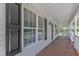 Inviting covered front porch featuring black shutters and a view of the landscaped surroundings at 52 Malcolm Dr, Clayton, NC 27520