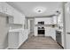 Well-lit kitchen with white cabinets, modern stainless steel appliances, and gray walls at 52 Malcolm Dr, Clayton, NC 27520