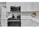 Close-up of a modern kitchen equipped with stainless steel appliances and sleek white countertops at 52 Malcolm Dr, Clayton, NC 27520