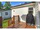 Back patio featuring brown wooden deck and stairs, white siding, black grill, and fenced yard at 527 N Cypress St, Wendell, NC 27591