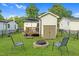 Spacious backyard with a fire pit, patio area, shed, green grass, and black fencing at 527 N Cypress St, Wendell, NC 27591