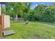 Well-kept backyard with a fire pit, lounge chairs, green grass, and partial fencing at 527 N Cypress St, Wendell, NC 27591
