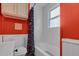 View of a bright bathroom with white cabinets, a red wall, and a blue patterned shower curtain at 527 N Cypress St, Wendell, NC 27591