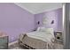 Charming bedroom featuring lilac walls, white trim, natural light and a white metal bed frame at 527 N Cypress St, Wendell, NC 27591