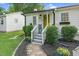Charming cottage with a bright yellow front door and lush landscaping at 527 N Cypress St, Wendell, NC 27591