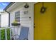 Cozy front porch with a bright yellow door, plants and a decorative lamp at 527 N Cypress St, Wendell, NC 27591