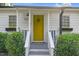 Charming yellow front door with wreath, framed by lush greenery and window box at 527 N Cypress St, Wendell, NC 27591