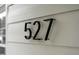 Close-up of the modern black house number '527' on a white exterior wall at 527 N Cypress St, Wendell, NC 27591