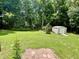 A backyard with green grass, tall trees, and a storage shed at 55 Ridge Haven Dr, Louisburg, NC 27549