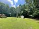 A grassy backyard with a storage shed and tall trees at 55 Ridge Haven Dr, Louisburg, NC 27549