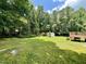 Expansive backyard featuring lush lawn, storage shed, and surrounding mature trees at 55 Ridge Haven Dr, Louisburg, NC 27549
