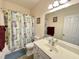 Neutral toned bathroom with vanity, toilet, tub, and a shower with patterned curtain at 55 Ridge Haven Dr, Louisburg, NC 27549