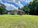 A backyard with green grass, a house with a screened-in porch, and tall trees at 55 Ridge Haven Dr, Louisburg, NC 27549