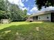A backyard with green grass, a house with a screened-in porch, and tall trees at 55 Ridge Haven Dr, Louisburg, NC 27549