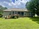 A backyard with green grass, a house with a screened-in porch, and tall trees at 55 Ridge Haven Dr, Louisburg, NC 27549