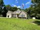 Beautiful home with well-manicured lawn, flagpole, and storage shed in a serene, wooded setting at 55 Ridge Haven Dr, Louisburg, NC 27549