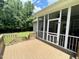 A screened-in porch with a brown wooden deck and stairs to a grassy yard with tall trees in the background at 55 Ridge Haven Dr, Louisburg, NC 27549