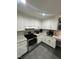 Kitchen with stainless steel appliances, white cabinets and backsplash, and light colored countertops at 5809 Iris Lake Ct, Raleigh, NC 27604