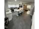 Open kitchen featuring grey tile floor, white cabinets and countertops, and a breakfast bar with two bar stools at 5809 Iris Lake Ct, Raleigh, NC 27604