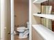 View of the downstairs bathroom and shelves with a stainless refrigerator nearby at 5810 Shady Grove Cir, Raleigh, NC 27609