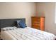 Neutral bedroom with a grey headboard, plaid blanket, and a wooden dresser at 5810 Shady Grove Cir, Raleigh, NC 27609
