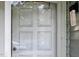 Close-up of a white front door with glass panels and an ornate exterior light fixture at 5810 Shady Grove Cir, Raleigh, NC 27609