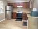 Well-lit kitchen with wood cabinets, stainless steel refrigerator, and updated appliances at 5810 Shady Grove Cir, Raleigh, NC 27609