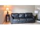 Relaxing living room area featuring a black leather sofa and ample lighting at 5810 Shady Grove Cir, Raleigh, NC 27609