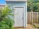 Storage shed in the backyard with blue siding and a secure door at 5810 Shady Grove Cir, Raleigh, NC 27609