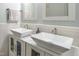 Bathroom featuring double sinks, marble countertops, and wainscoting at 6501 Battleford Dr, Raleigh, NC 27613