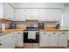 Bright kitchen with white cabinets, butcher block countertops, stainless steel oven, and subway tile backsplash at 6501 Battleford Dr, Raleigh, NC 27613