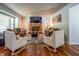 Bright living room boasts hardwood floors, cozy seating arrangements, a brick fireplace, and recessed lighting at 6501 Battleford Dr, Raleigh, NC 27613