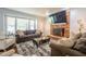 Inviting living room with a brick fireplace, large windows, plush sofa, comfortable chairs, and modern decor at 6501 Battleford Dr, Raleigh, NC 27613