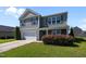 Charming two-story home with gray siding, complemented by a well-manicured front yard and a two car garage at 737 Botanical Ct, Bunnlevel, NC 28323