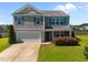 Two-story home with gray siding, complemented by a well-manicured front yard and a two car garage at 737 Botanical Ct, Bunnlevel, NC 28323