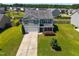 Aerial front elevation of two-story home with gray siding, complemented by a well-manicured front lawn and mature tree at 737 Botanical Ct, Bunnlevel, NC 28323