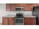 A well-lit kitchen features stainless steel appliances and wood cabinetry at 737 Botanical Ct, Bunnlevel, NC 28323