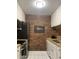 Galley kitchen featuring stainless steel appliances, butcher block counters, and brick accent wall at 807 W Trinity Ave # 209, Durham, NC 27701