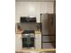Well-lit kitchen with stainless steel appliances, light gray backsplash, and white cabinets at 807 W Trinity Ave # 209, Durham, NC 27701