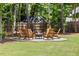 Inviting backyard featuring a stone fire pit with seating, perfect for entertaining at 8420 Bells Lake Rd, Apex, NC 27539