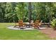 Inviting backyard featuring a stone fire pit with seating, perfect for entertaining at 8420 Bells Lake Rd, Apex, NC 27539