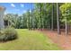 Spacious backyard features a fire pit surrounded by Adirondack chairs and a lush wooded backdrop at 8420 Bells Lake Rd, Apex, NC 27539