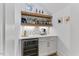 Modern bar area featuring a wine fridge, white countertops, and open wood shelving with tiled backsplash at 8420 Bells Lake Rd, Apex, NC 27539