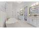 Elegant bathroom with double vanity, soaking tub, marble floors and modern fixtures at 8420 Bells Lake Rd, Apex, NC 27539