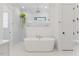 Bright bathroom with a freestanding tub, glass enclosed shower and modern fixtures at 8420 Bells Lake Rd, Apex, NC 27539