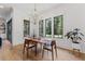 Bright dining room with hardwood floors, a modern chandelier, and large windows overlooking the backyard at 8420 Bells Lake Rd, Apex, NC 27539